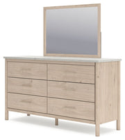 Signature Design by Ashley Cadmori six-drawer dresser with dark wood finish and sleek metal handles.