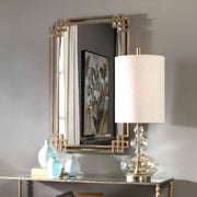 Devoll wall mirror by Uttermost with an antique gold finish, showcasing a stylish, reflective surface and elegant frame design.