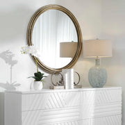 Uttermost Spera round wall mirror with a gold finish, featuring a sleek, modern design and a smooth circular frame.