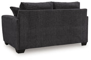 Benchcraft® Loreo stationary loveseat with plush fabric and modern design, shown in a cozy living room setting.