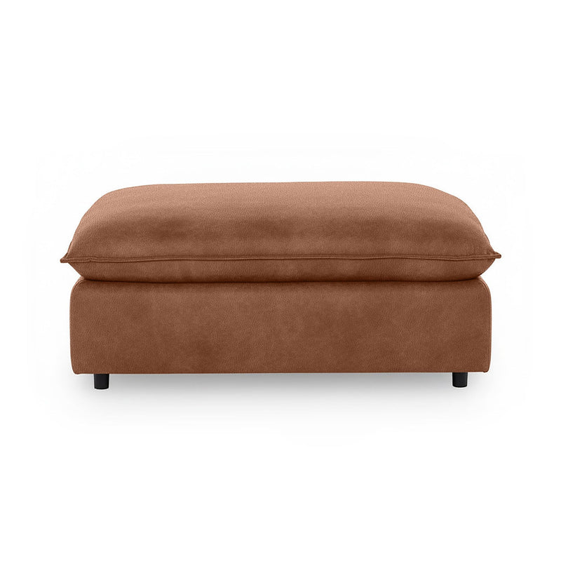 Classic Home Caplan upholstered ottoman with a plush fabric finish, serving as a versatile footrest or accent piece.