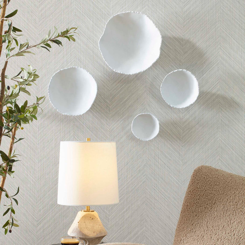Set of four Uttermost Lucky Coins wall decor bowls with intricate designs, mounted on a wall as decorative art pieces.