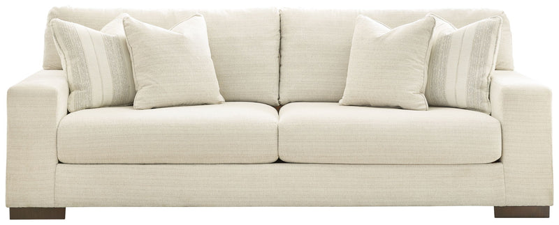 Signature Design by Ashley Maggie stationary sofa with plush cushions and neutral upholstery in a modern living room setting.