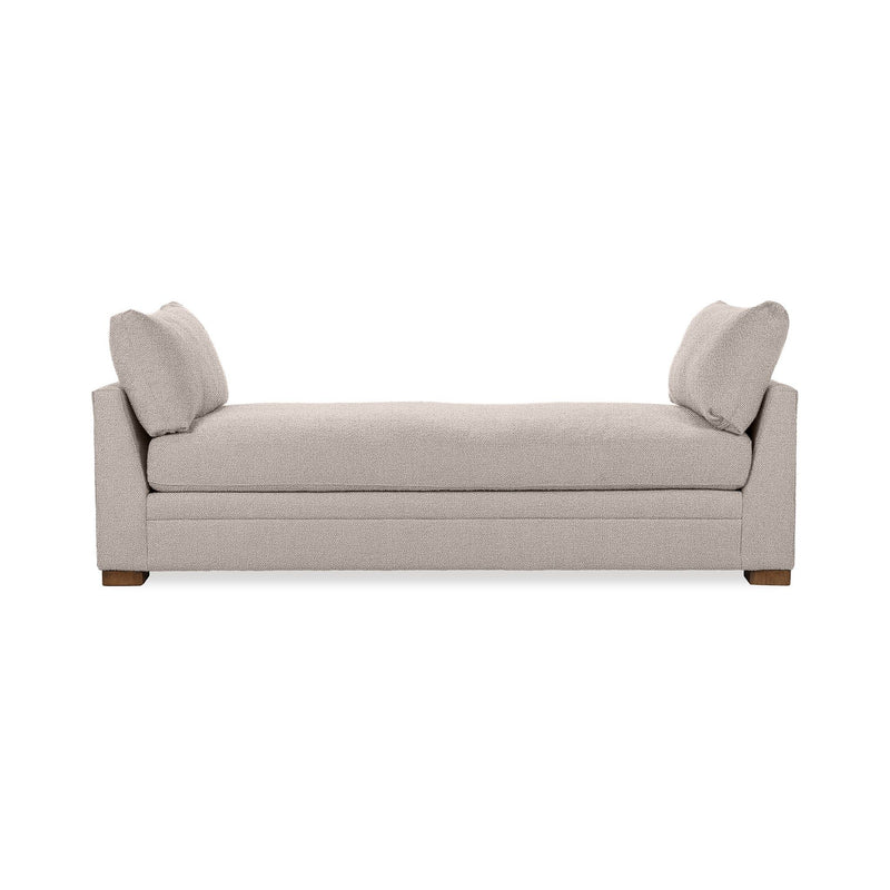 Classic Home Audrey daybed with a wooden frame and neutral upholstery, shown with decorative pillows in a cozy bedroom setting.