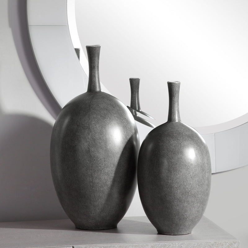 Set of two black Riordan modern vases by Uttermost, featuring sleek cylindrical design and matte finish, ideal for contemporary decor.