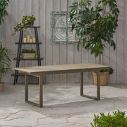 Outdoor expandable acacia wood dining table with U-shaped legs by Noble House, showing the table extended with a natural wood finish.