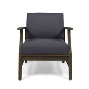 Noble House outdoor club arm chair with dark gray water-resistant cushion and slat panel design in a cozy patio setting