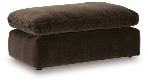 Benchcraft® Maxton Heights upholstered ottoman with plush fabric and wooden legs, used as a footrest or versatile accent piece.