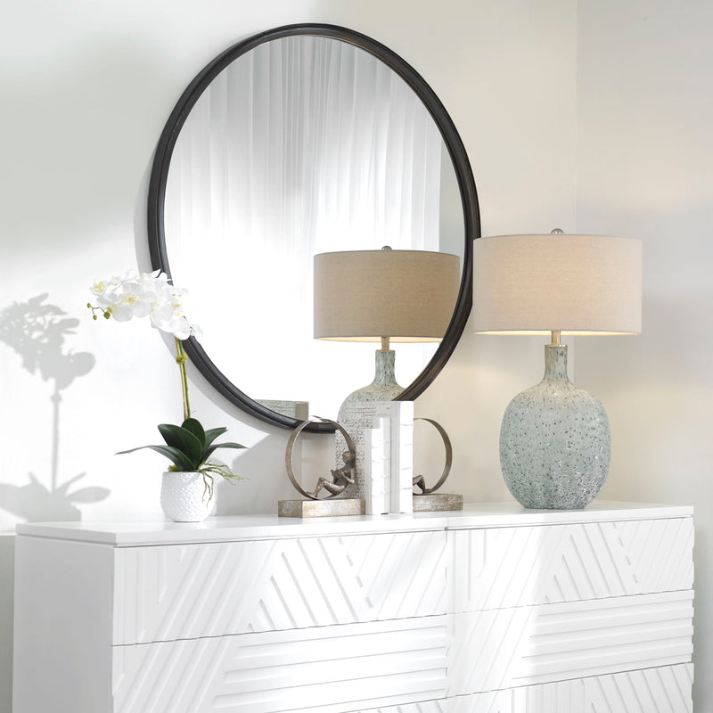 Black Dawsyn round accent mirror by Uttermost showing a sleek, circular mirror with a modern black frame.