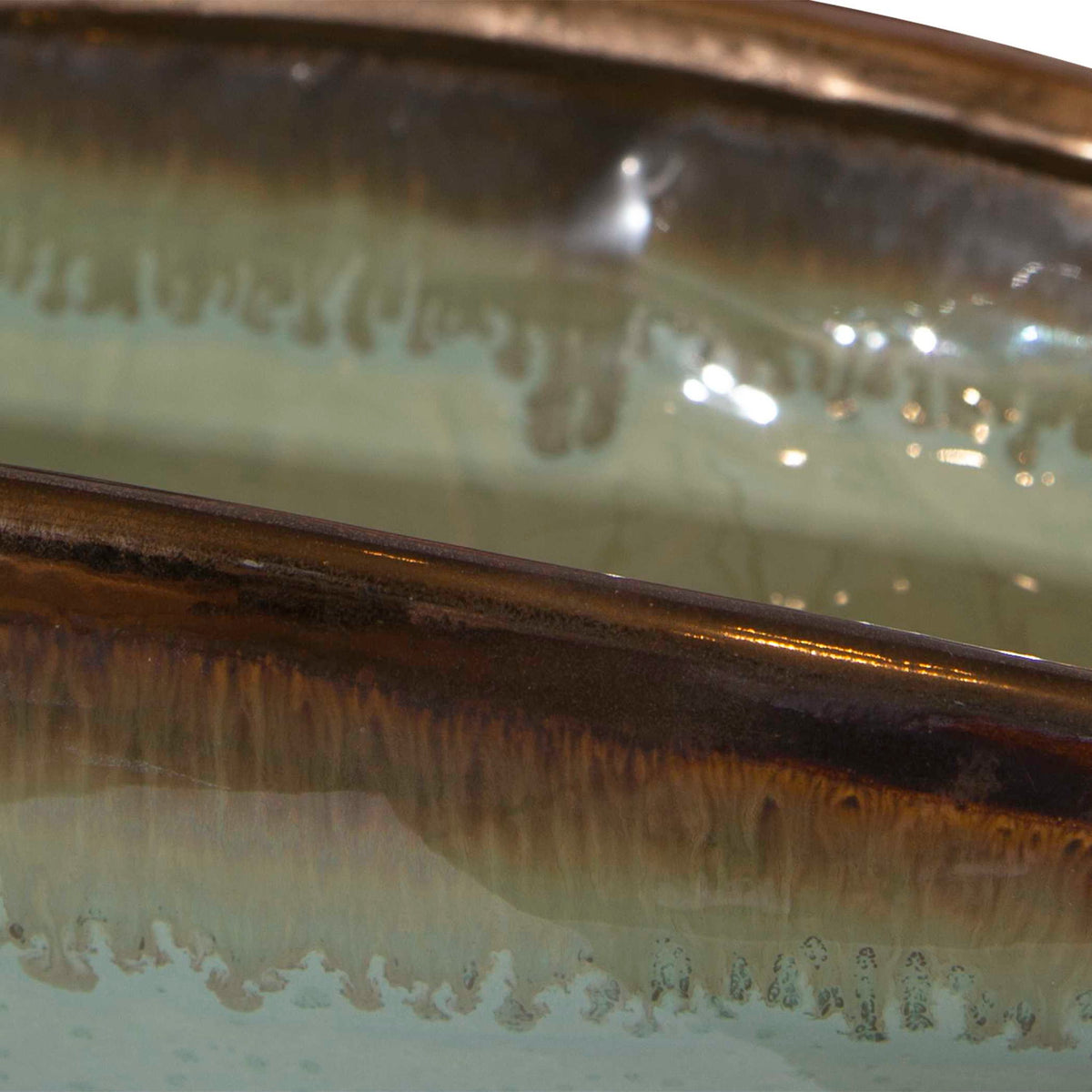 Green glaze bowl from Uttermost's Iroquois collection, showcasing a smooth, rounded ceramic plate with a glossy finish.