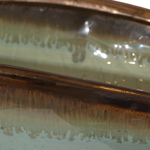 Green glaze bowl from Uttermost's Iroquois collection, showcasing a smooth, rounded ceramic plate with a glossy finish.