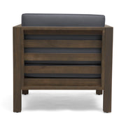 Noble House outdoor acacia wood patio arm chair with fabric cushion, showing a sturdy wooden frame and comfortable seating for outdoor spaces.