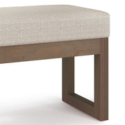 Simpli-Home Milltown upholstered ottoman bench with cushioned top and wooden legs, suitable for living room or bedroom decor.