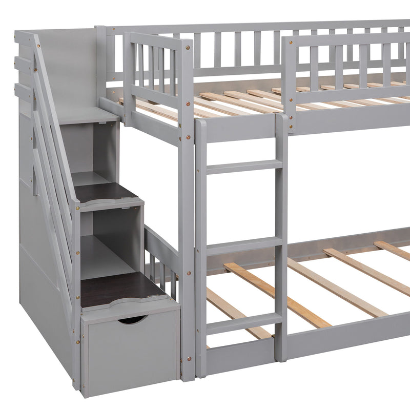 DreamHaus gray twin over twin bunk bed with stairway, two drawers, and slide, featuring a sturdy wooden frame and safety railings.