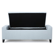 Noble House Guernsey storage ottoman with tufted top, beige fabric, and wooden legs, serving as a stylish storage and seating solution.