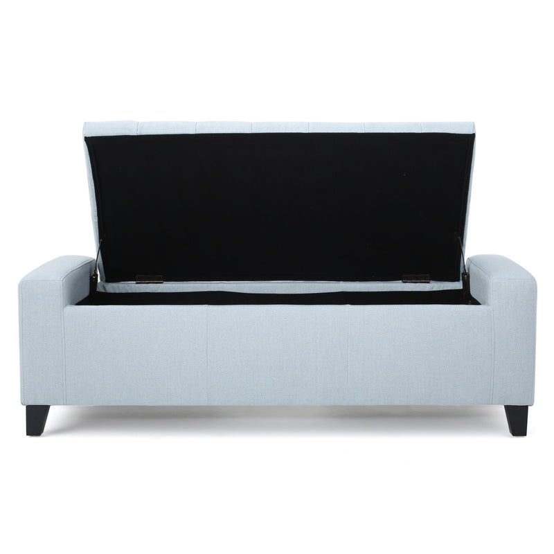 Noble House Guernsey storage ottoman with tufted top, beige fabric, and wooden legs, serving as a stylish storage and seating solution.