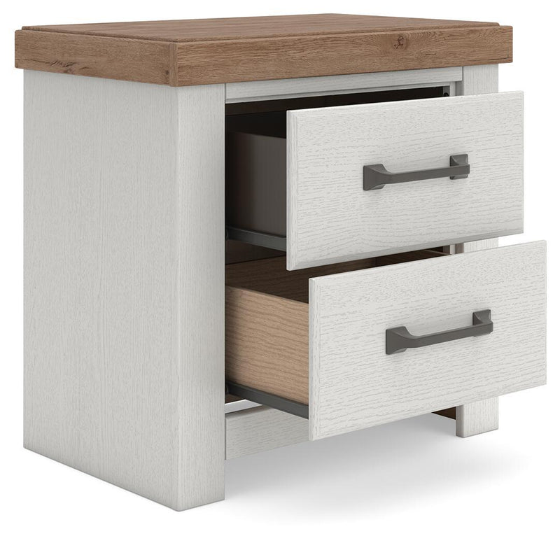 Benchcraft® white and brown two-drawer night stand with charging station, featuring sleek design and modern storage.