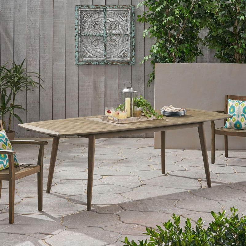 Noble House Placidity outdoor expandable dining table with slatted tabletop and tapered legs, perfect for patio or garden dining.
