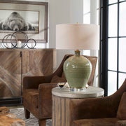 Uttermost Elva table lamp with emerald green ceramic base and a neutral fabric shade, perfect for modern living spaces.