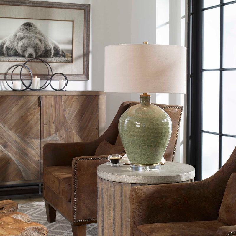 Uttermost Elva table lamp with emerald green ceramic base and a neutral fabric shade, perfect for modern living spaces.