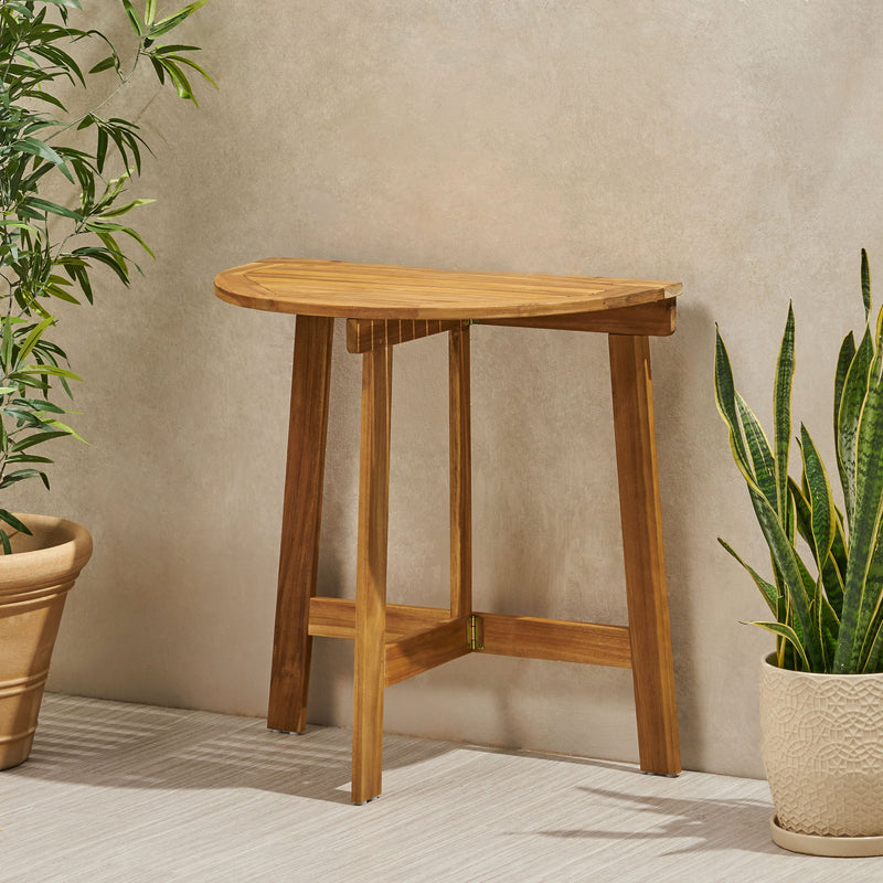 Outdoor Noble House half round folding bistro table made of acacia wood, designed for compact outdoor dining and patio use.
