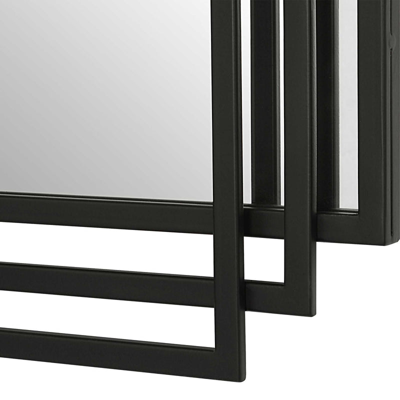 Uttermost Amherst wall mirror with a sleek, modern frame, hanging on a wall in a contemporary interior.