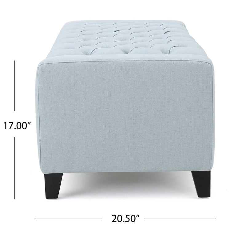 Noble House Guernsey storage ottoman with tufted top, beige fabric, and wooden legs, serving as a stylish storage and seating solution.