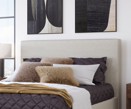 Ivory upholstered Olivia queen-size headboard by Modus with plush fabric and elegant design, displayed on a bed frame.