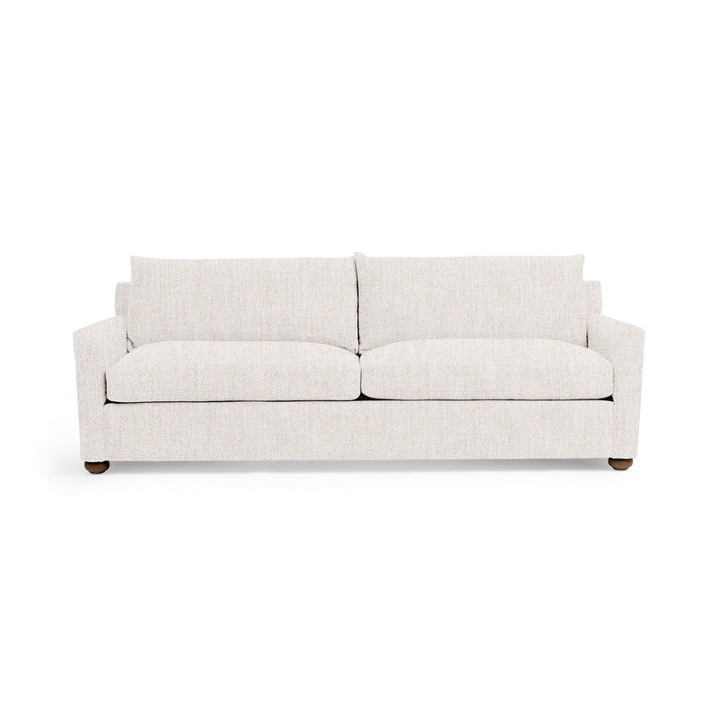 Olivia stationary sofa by Classic Home with plush beige upholstery and tufted backrest, placed in a modern living room setting.