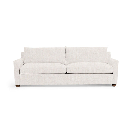 Olivia stationary sofa by Classic Home with plush beige upholstery and tufted backrest, placed in a modern living room setting.