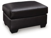 Midnight upholstered ottoman from the Glennbre collection by Signature Design by Ashley®, featuring plush fabric and modern style.