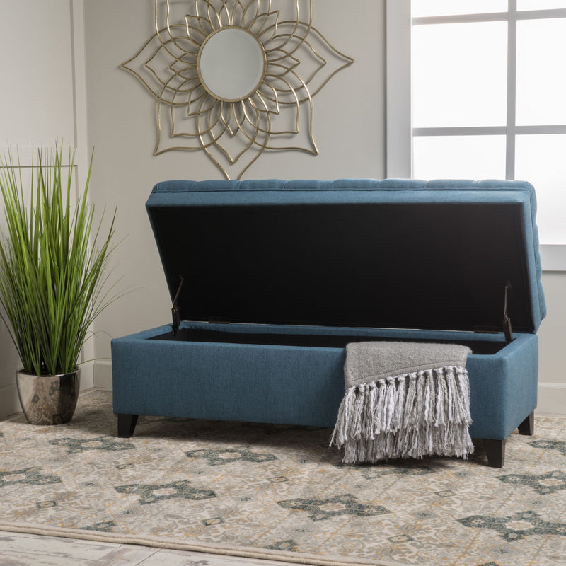 Noble House Juliana storage ottoman with birch wood legs, cushioned beige fabric, and spacious interior for versatile storage.
