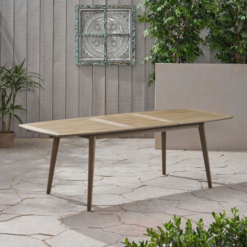 Noble House Placidity outdoor expandable dining table with slatted tabletop and tapered legs, ideal for patio or garden dining.