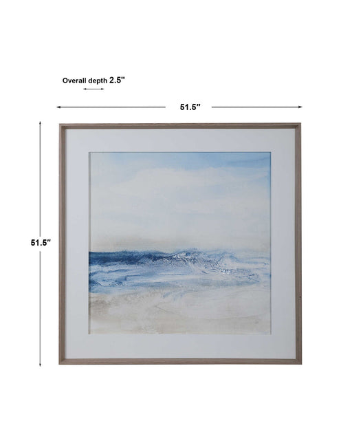 Framed print titled "Surf and Sand" by Uttermost featuring a serene blue beach scene with waves and sand in a stylish frame.
