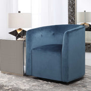 Blue Uttermost Mallorie swivel chair with plush upholstered seat and sleek modern design, shown from a side angle.
