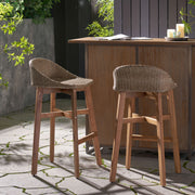 Set of two Noble House Beeson outdoor wicker and acacia wood barstools in brown with water-resistant finish, perfect for patio seating.