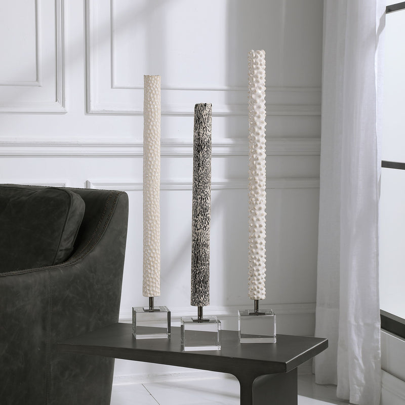 Set of three Pearl Silver cylindrical sculptures by Uttermost, modern decorative figurines with sleek, metallic finishes.
