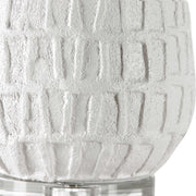 White textured Caelina table lamp by Uttermost with a sleek, modern design, featuring a rounded base and fabric shade.