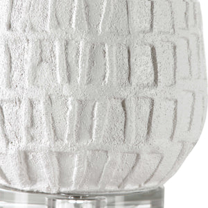 White textured Caelina table lamp by Uttermost with a sleek, modern design, featuring a rounded base and fabric shade.