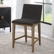 Uttermost Klemens counter stool with wooden frame and cushioned seat, 24-27 inch height, in a modern design.
