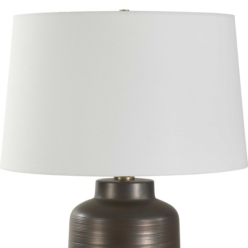 Uttermost Calderone bronze table lamp with a sleek, modern design and a textured ceramic base, perfect for contemporary decor.