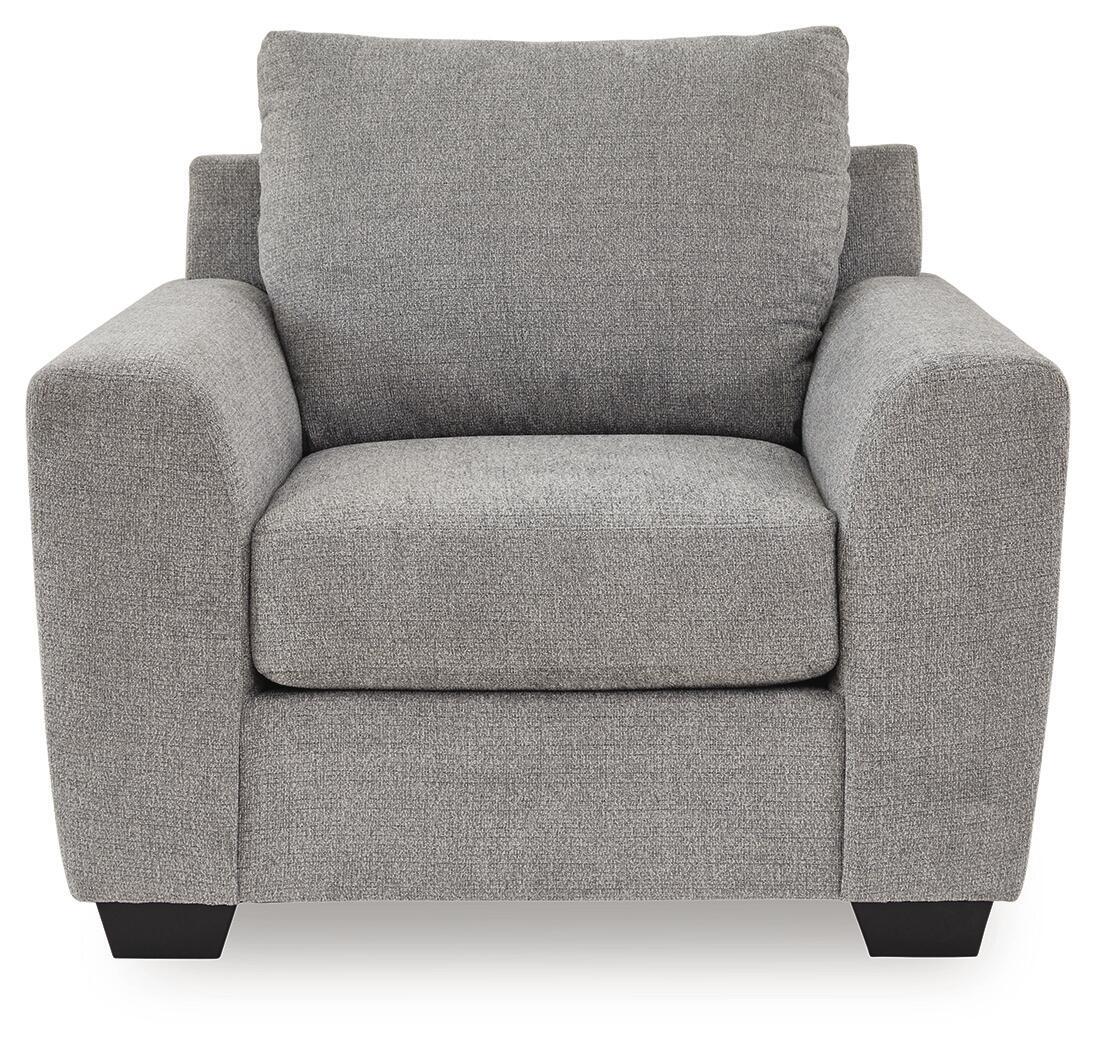 Benchcraft® Loreo arm chair with plush fabric upholstery and padded armrests, shown in a cozy living room setting.