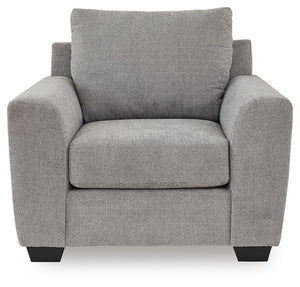 Benchcraft® Loreo arm chair with plush fabric upholstery and padded armrests, shown in a cozy living room setting.