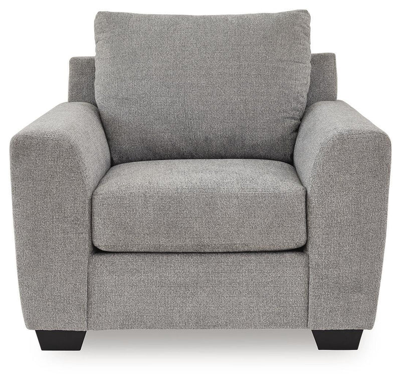 Benchcraft® Loreo arm chair with plush fabric upholstery and padded armrests, shown in a cozy living room setting.