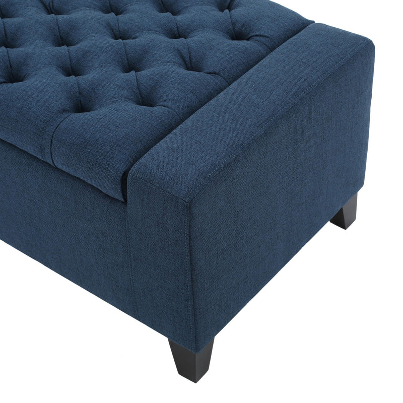 Noble House Guernsey storage ottoman with tufted top, beige fabric, and sturdy wooden legs, serving as a stylish home storage piece.