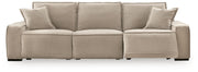 Benchcraft Carceri reclining sectional sofa with plush cushions and fabric upholstery, shown in a spacious living room setting.