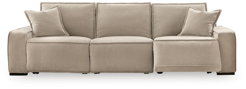 Benchcraft Carceri reclining sectional sofa with plush cushions and fabric upholstery, shown in a spacious living room setting.