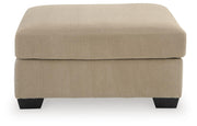 SimpleJoy oversized accent ottoman by Signature Design Ashley, showing plush fabric and sturdy wooden legs in a modern living room.