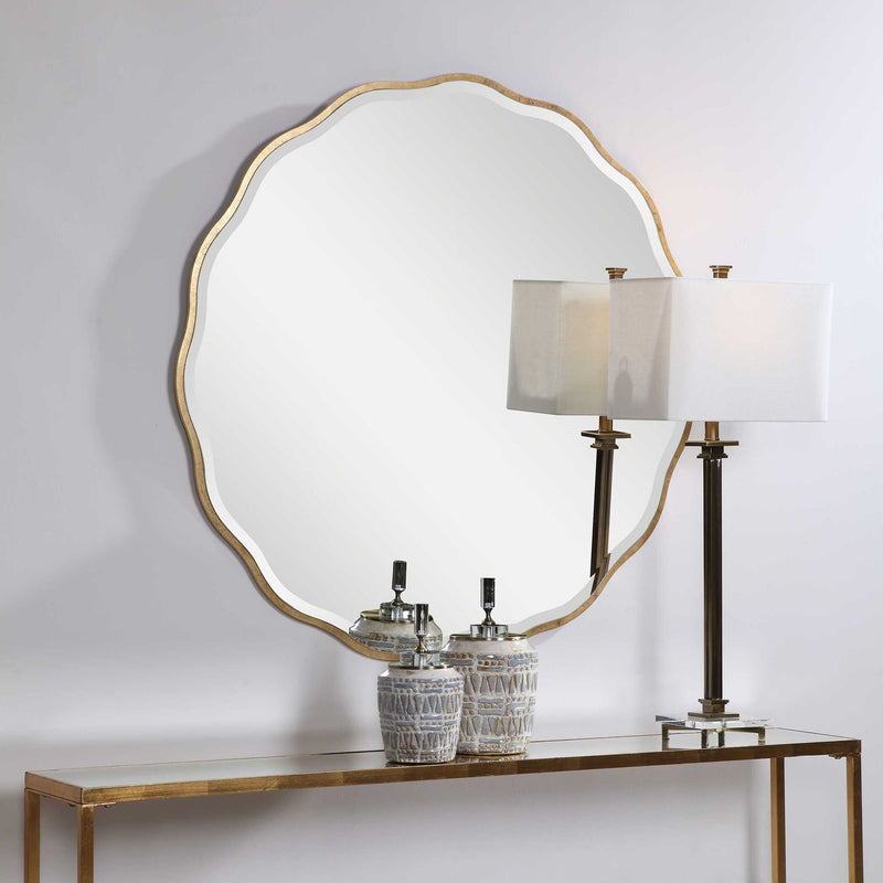 Uttermost Aneta round wall mirror with a sleek frame, hanging on a wall, showcasing its modern design and reflective glass surface.