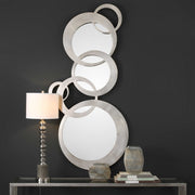 Modern silver Odiana wall mirror by Uttermost featuring a sleek, circular design with a reflective mirror surface.